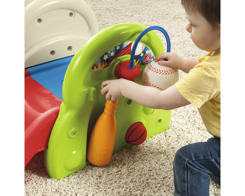 Un enfant joue avec un centre sportif Step2, équipé d''une balle de base-ball, d''une balle de basket-ball et d''une batte