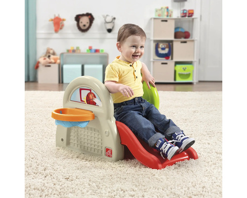 Un jeune enfant joue sur un toboggan pour enfants avec un panier de basket à l''intérieur.