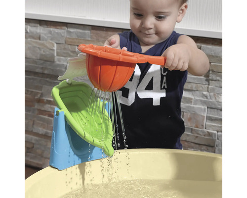 Un enfant joue avec un jouet aquatique au-dessus d''un bassin d''eau