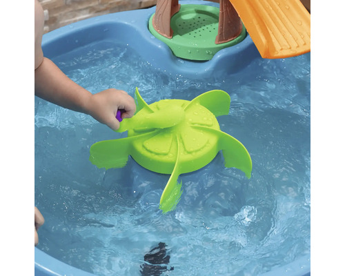 Kind spielt mit Wasserrad in einem Wasserbecken