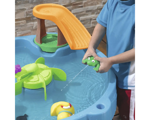 Wasserspieltisch mit Rutsche und Kind, das mit Froschspielzeug spritzt