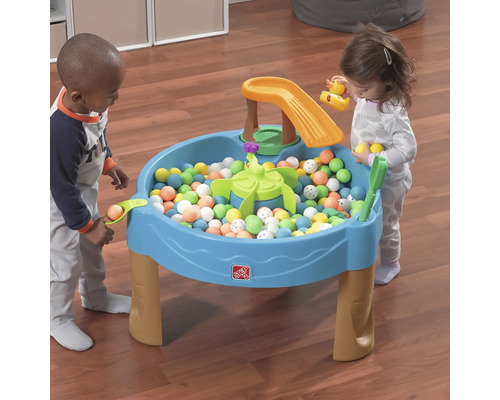 Zwei Kinder spielen mit einem Step2-Aktivitätstisch mit Bällen und Wasserspielzeug