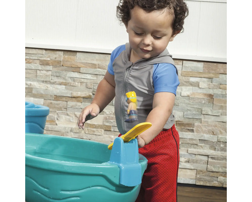 Un enfant joue avec une table de jeu d''eau à l''extérieur