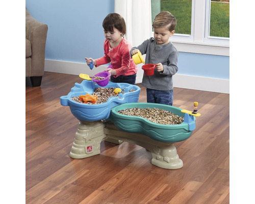 Deux enfants jouent à une table de sable et d''eau Step2 avec des accessoires.