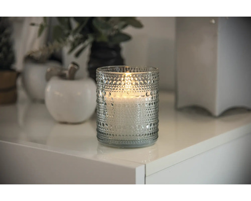 Bougie décorative en verre sur une table blanche