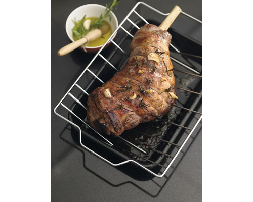 Gebratene Lammkeule mit Knochen auf einem Backblech mit Rost