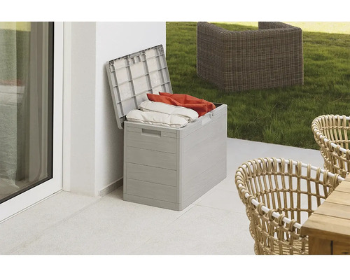 Geöffnete Aufbewahrungsbox aus Kunststoff mit Kissen auf einer Terrasse