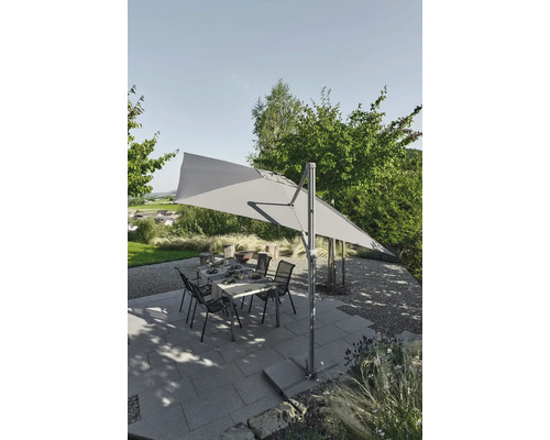 Gartenszene mit rechteckigem Sonnenschirm, Tisch und Stühlen auf einer Terrasse