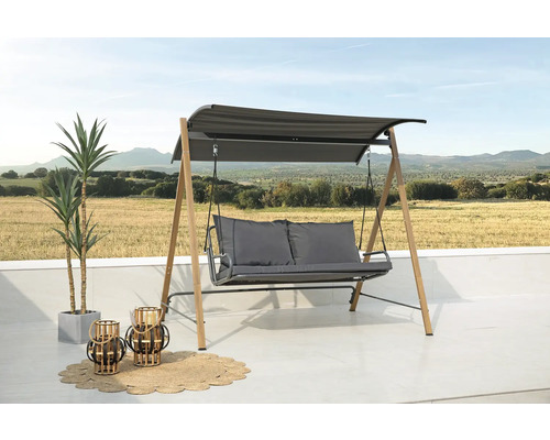 Balancelle de jardin avec toit, coussins d''assise, deux lanternes et un tapis sur une terrasse