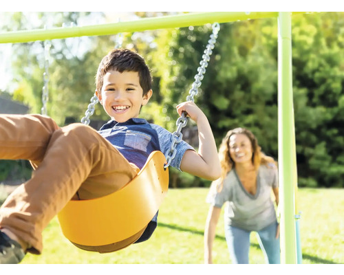 Un enfant se balance sur une balançoire dans le jardin.