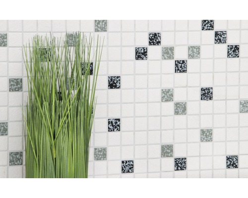 Plante artificielle décorative devant un mur avec de petites mosaïques