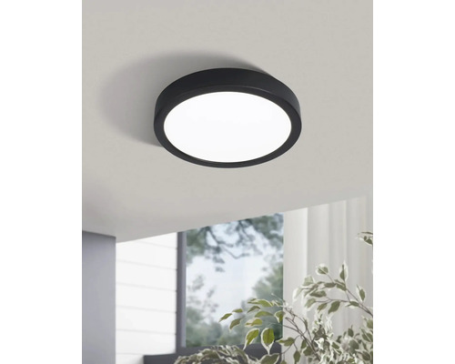 Runde Deckenleuchte mit schwarzem Rahmen im Raum