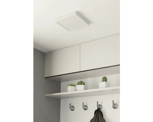 Quadratische Deckenleuchte in einem Raum mit Regalen und Hakenleiste.