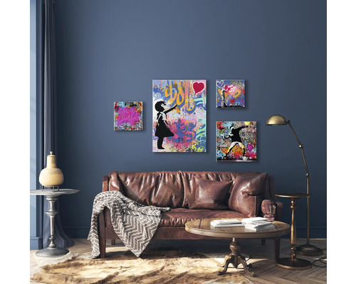 Salon avec canapé en cuir marron, table en bois et décoration murale avec motifs de graffitis