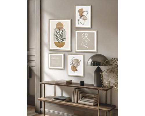 Wanddekoration mit Rahmen und abstrakten Motiven über einem Regal mit Büchern