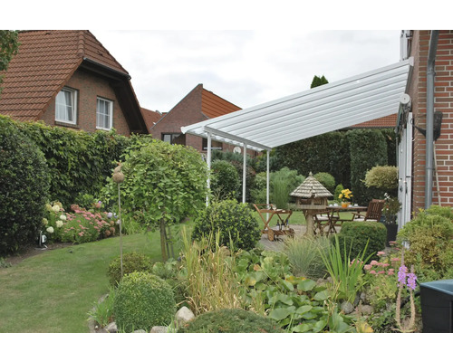 Pergola de terrasse en aluminium avec mobilier de jardin dans un jardin.