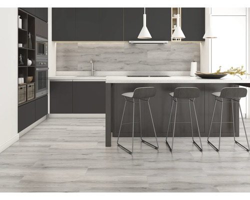 Cuisine moderne avec armoires sombres, îlot de cuisine avec tabourets de bar et plancher en bois clair