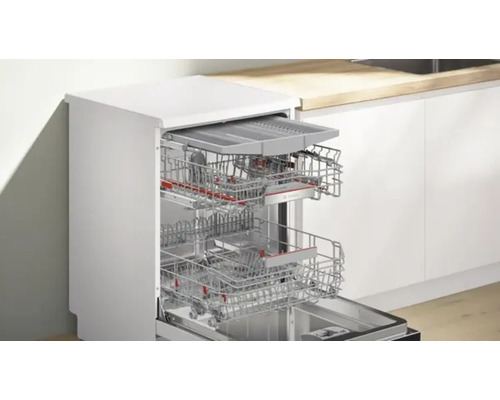 Geöffneter Geschirrspüler mit Geschirrkörben in einem Küchenraum.