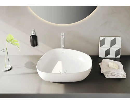 Salle de bain moderne avec vasque à poser, robinet, miroir et décoration