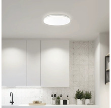 Plafonnier dans une cuisine claire avec des armoires et des plans de travail blancs.