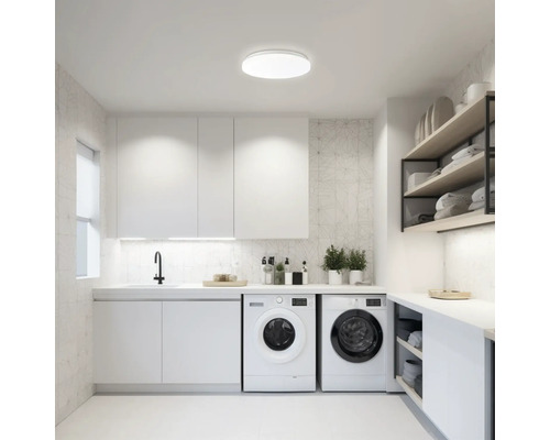 Buanderie lumineuse avec machines à laver, lavabo, armoires et étagères pour l''entretien du linge