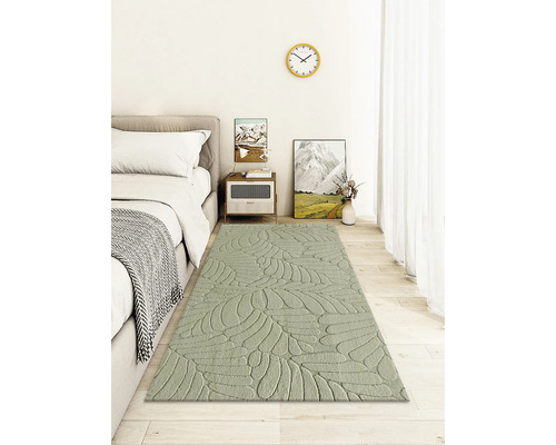 Schlafzimmer mit Bett, Nachttisch und Teppich mit Blattmuster