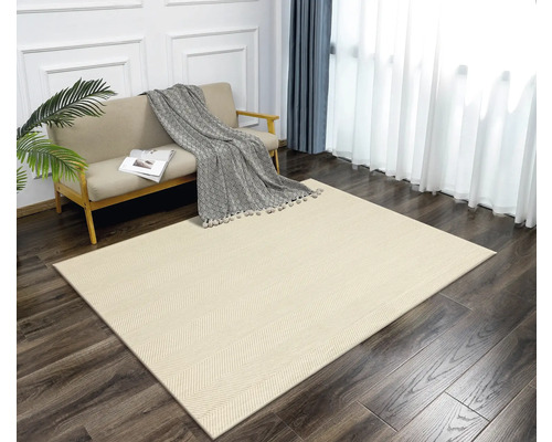 Ein Wohnzimmer mit einem hellen Teppich mit Fischgrätenmuster, einem Sofa, Vorhängen und einer Zimmerpflanze