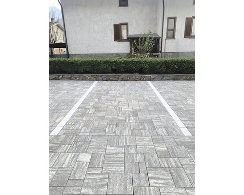 Extérieur avec pavés et marquages de stationnement devant un bâtiment