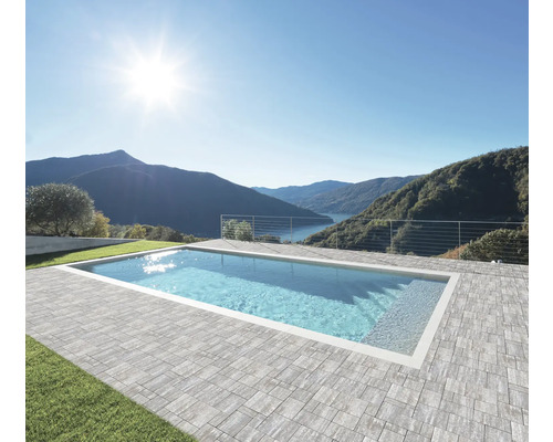 Piscine rectangulaire avec bordure en pierre et vue sur le lac et les montagnes