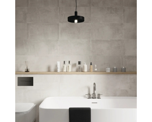 Salle de bain moderne avec baignoire, toilettes, étagère et carrelage mural gris