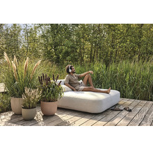 Scène avec des pots de fleurs plantés et une personne se détendant sur un banc de jardin à l''extérieur