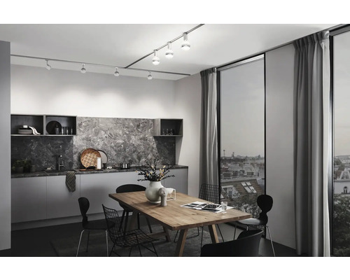 Cuisine moderne avec table à manger, chaises et système de rails avec spots pour l''éclairage.