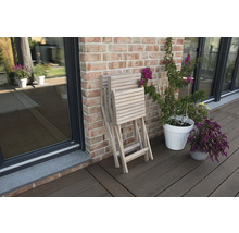 Zusammengeklappter Gartentisch aus Holz neben Blumen auf einer Terrasse