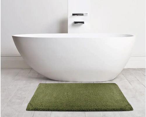 Baignoire îlot avec tapis de bain rectangulaire dans la salle de bains.