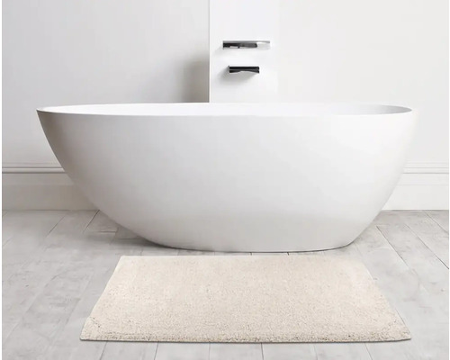 Baignoire îlot avec tapis de bain dans la salle de bain.
