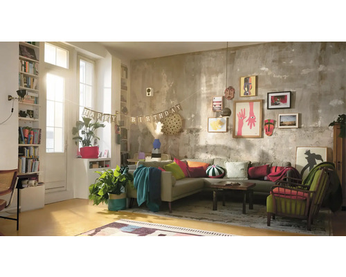 Wohnzimmer mit Sofa, Sesseln, dekorativer Wand und Geburtstagsdekoration