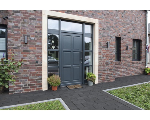 Porte d''entrée avec parties latérales et imposte dans une maison en brique avec pavés