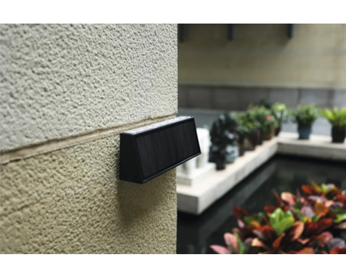 Wandleuchte mit Solarpanel an einer Hauswand