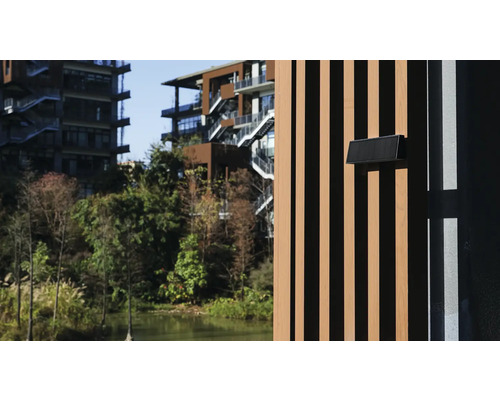 Ansicht eines modernen Gebäudes mit Holzfassade und Briefkasten in einer grünen Umgebung