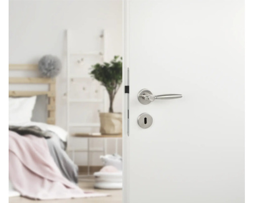 Porte blanche ouverte avec poignée de porte argentée dans la chambre