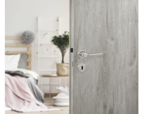 Porte intérieure grise avec poignée de porte argentée devant la chambre