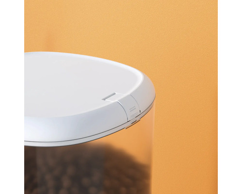 Vue détaillée d''un distributeur automatique de nourriture avec récipient transparent et couvercle blanc