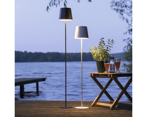 Deux lampadaires sur une terrasse en bois avec vue sur un lac.