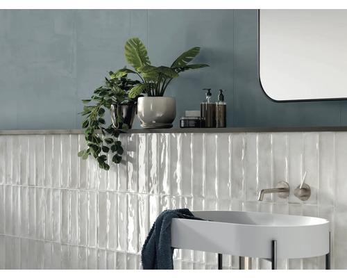 Modernes Badezimmer mit weißen Keramikfliesen, Waschbecken und Dekoration