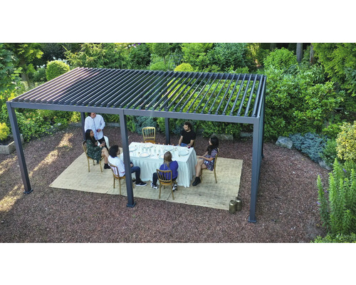 Scène avec un groupe de personnes sous une pergola dans le jardin, assis à une table à manger.
