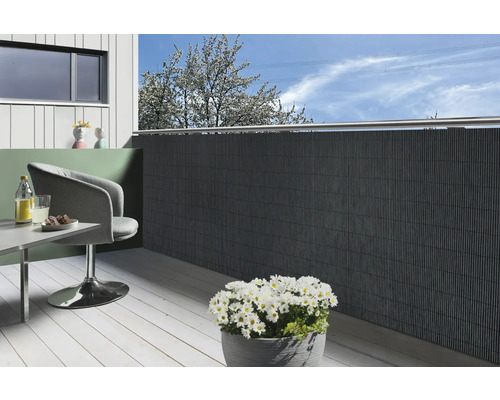 Balcon avec brise-vue, chaise, table et pot de fleurs avec des marguerites