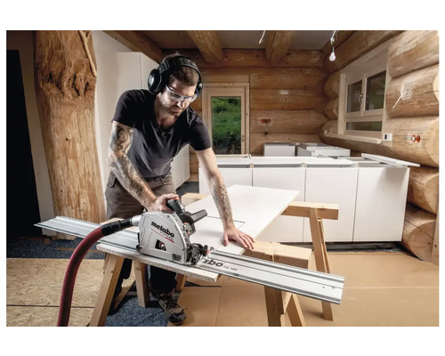 Un homme scie une pièce à travailler sur un chantier avec une scie plongeante Metabo.