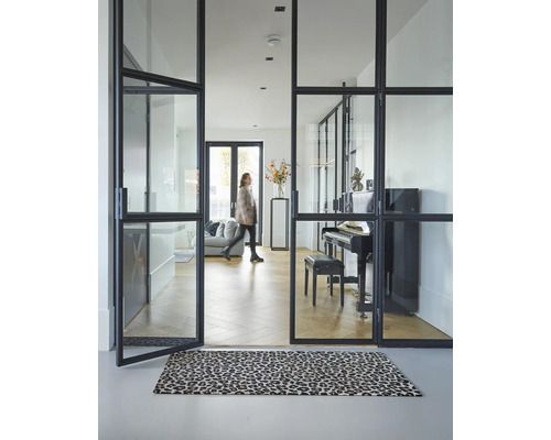 Heller Raum mit Glastüren und Teppich mit Tiermuster