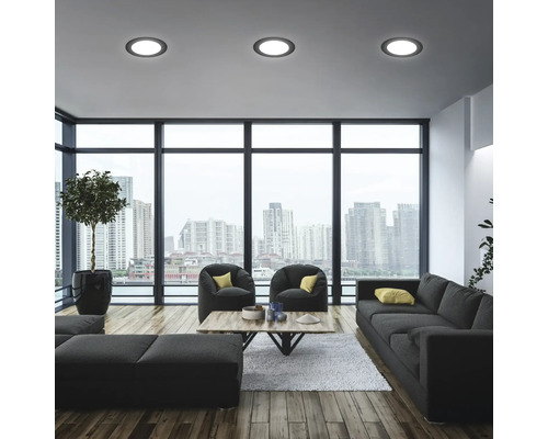 Helles Wohnzimmer mit Sofa, Sesseln und Deckeneinbaustrahlern