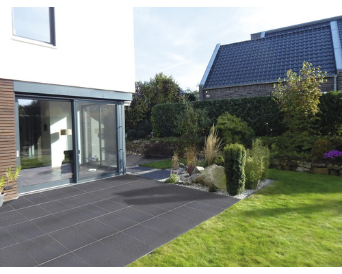Jardin avec terrasse en dalles de pierre, attenant à une maison d''habitation moderne